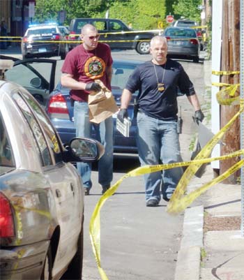 Investigators emerge from a car on Shurtleff Street last Thursday afternoon after recovering ballistics evidence from the vehicle.