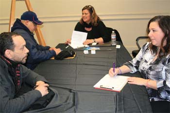 Human Resources workers interview Chelsea residents John Rosado (foreground) and "Jimmy" (back) at the Feb. 6 job fair for Chelsea residents seeking work at the upcoming hotel projects.